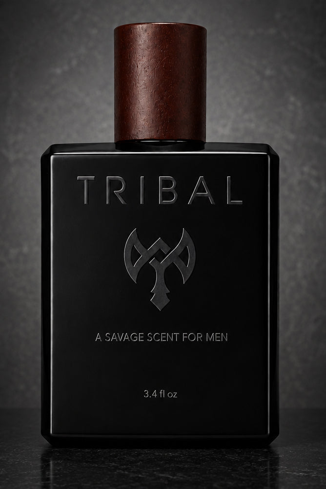 A rectangular black fragrance bottle labeled TRIBAL with a metallic copper-brown cap, photographed against a dark textured gray background.