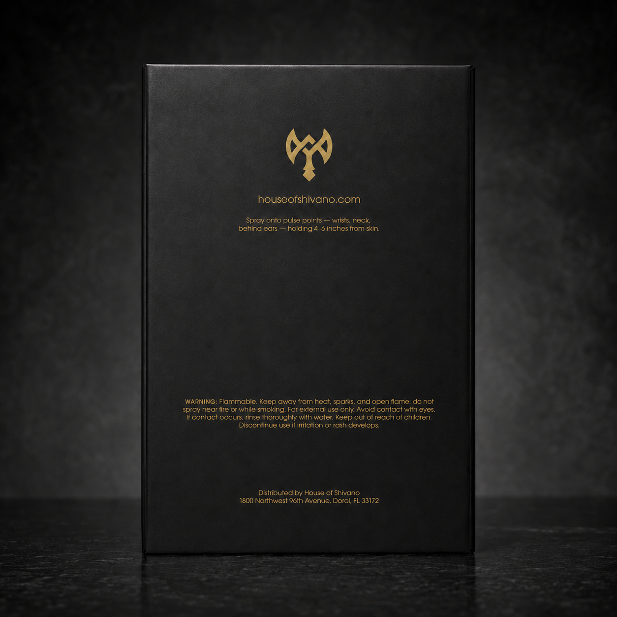 A tall black rectangular product box standing upright on a dark surface, with gold text and a gold logo on the front. The visible brand text reads houseatthivana.
